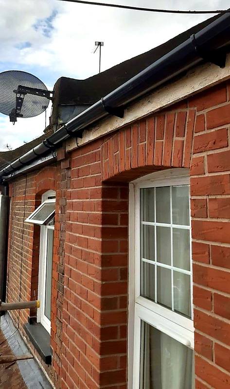 Red brick slips with a new black gutter on a rear extension in the West Midlands