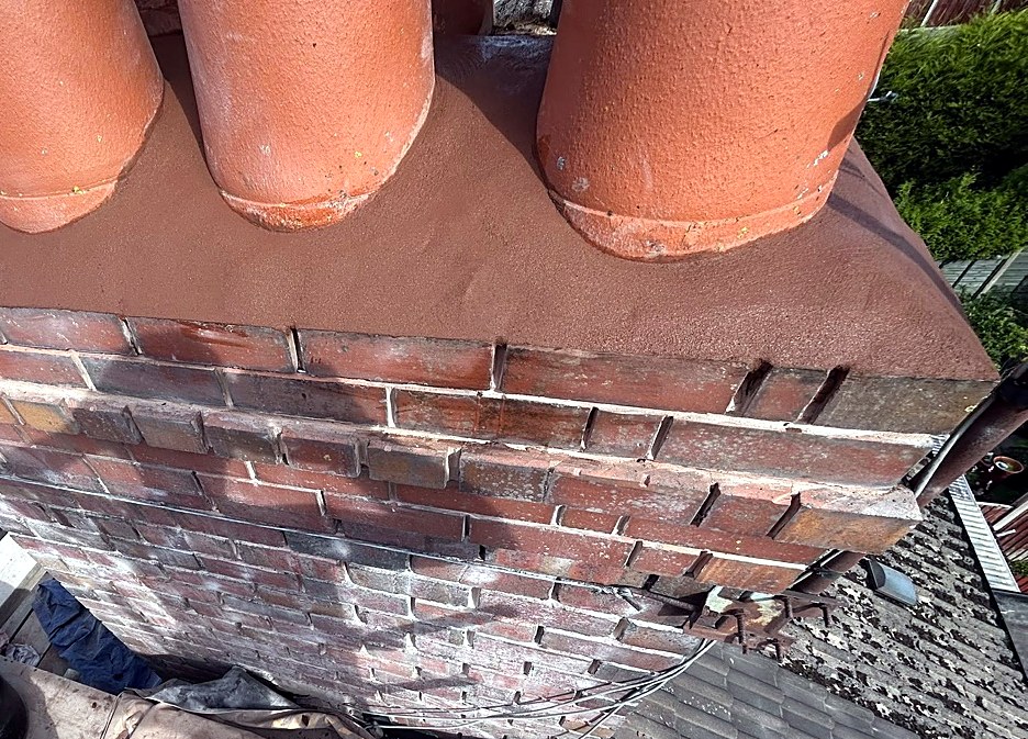Chimney stack repointed with fresh mortar flaunching around four pots