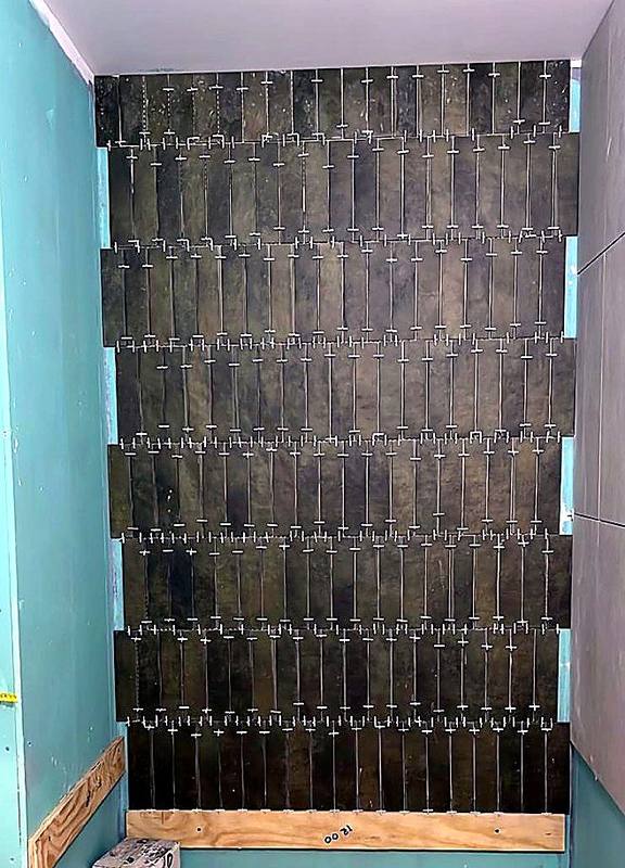 Green vertical feature tiles being laid with levelling clips in the West Midlands
