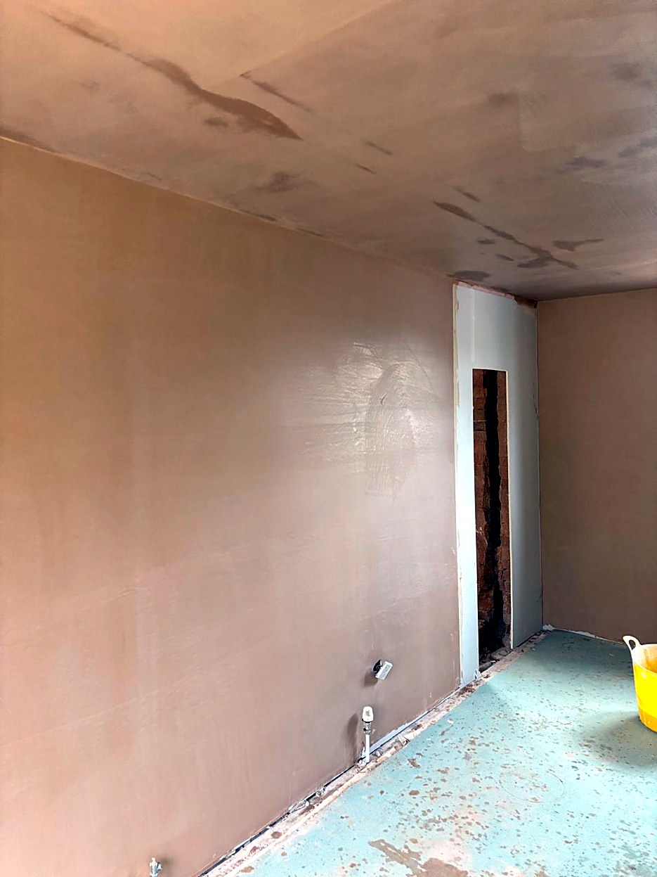Freshly plastered walls and ceiling in an empty room