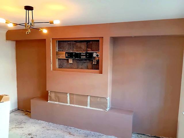Plastered media wall with a TV recess and alcoves either side in the West Midlands