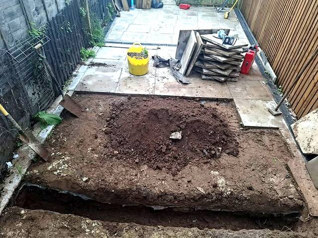 Patio slabs lifted and a trench dug across the garden for new drainage in Northfield