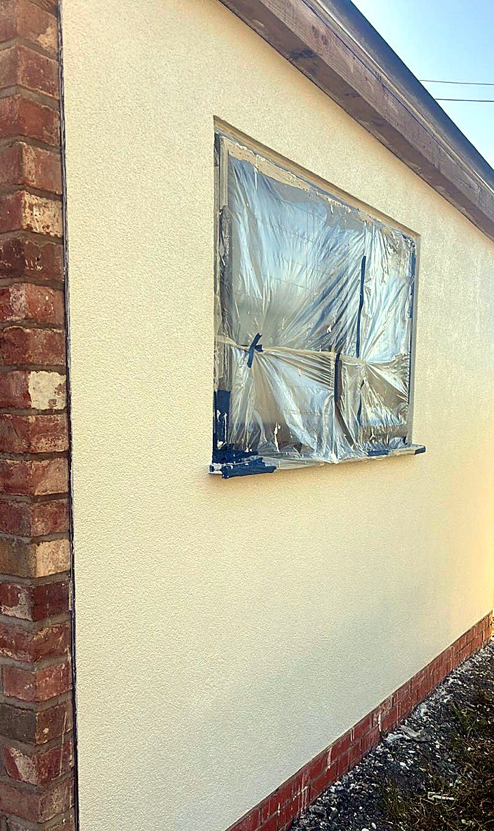 Close view of a textured render finish beside a window