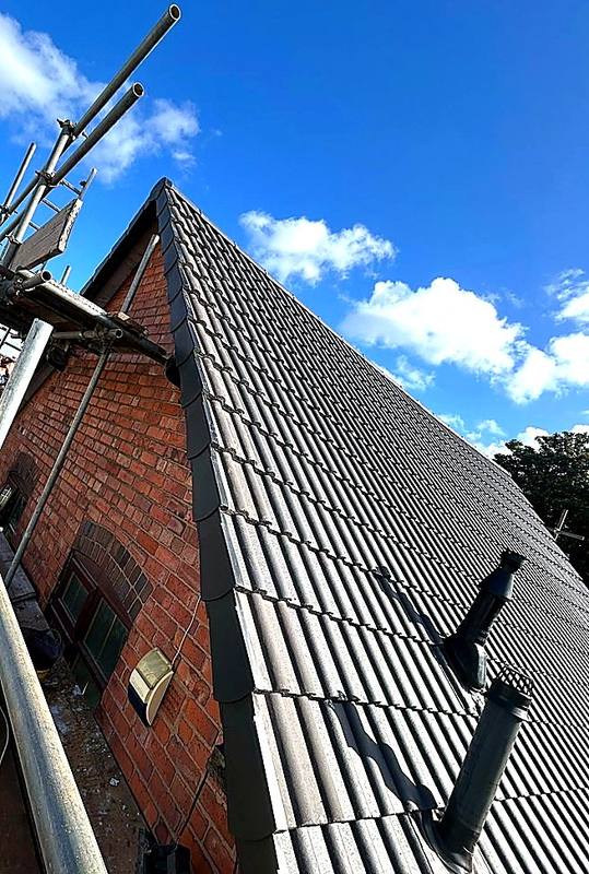 Brick gable end with a newly tiled roof and dry verge in Halesowen